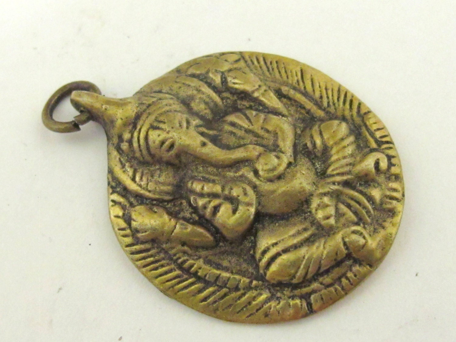Oval Shape Seated four armed Ganesha brass charm pendant from Nepal - CP054