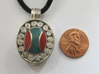 Oval shape Tibetan silver finish Ghau prayer box pendant with turquoise coral inlay and double spiral design - PM191E