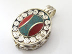Oval shape Tibetan silver finish Ghau prayer box pendant with turquoise coral inlay and double spiral design - PM191E