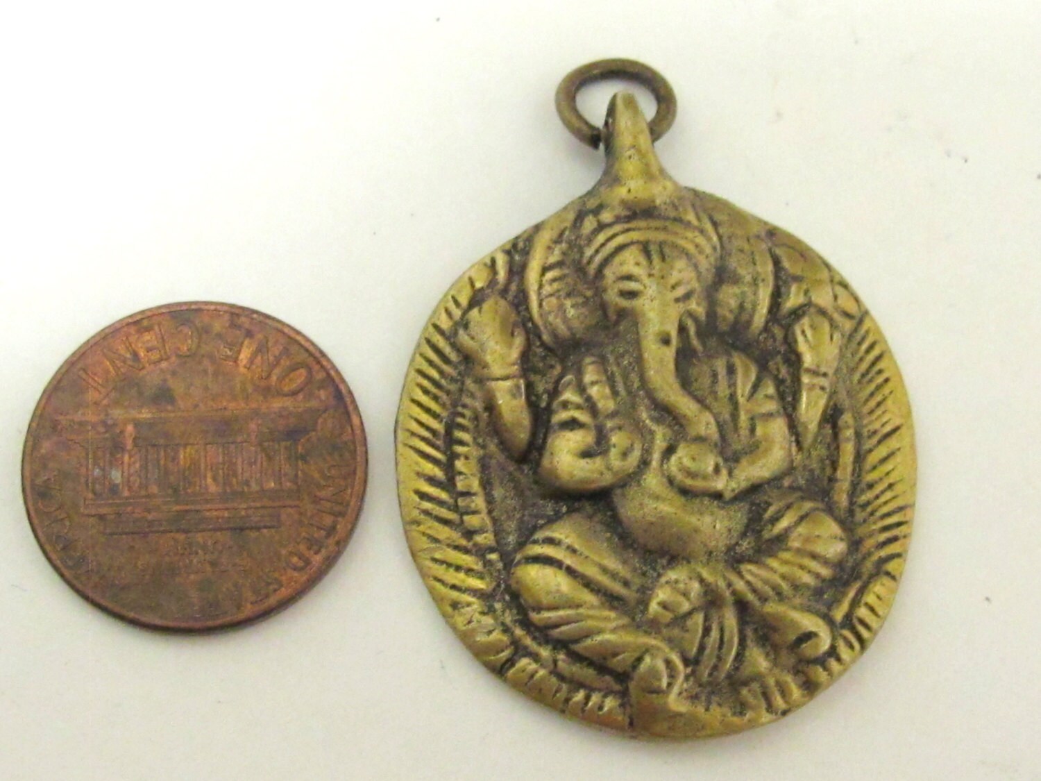 Oval Shape Seated four armed Ganesha brass charm pendant from Nepal - CP054